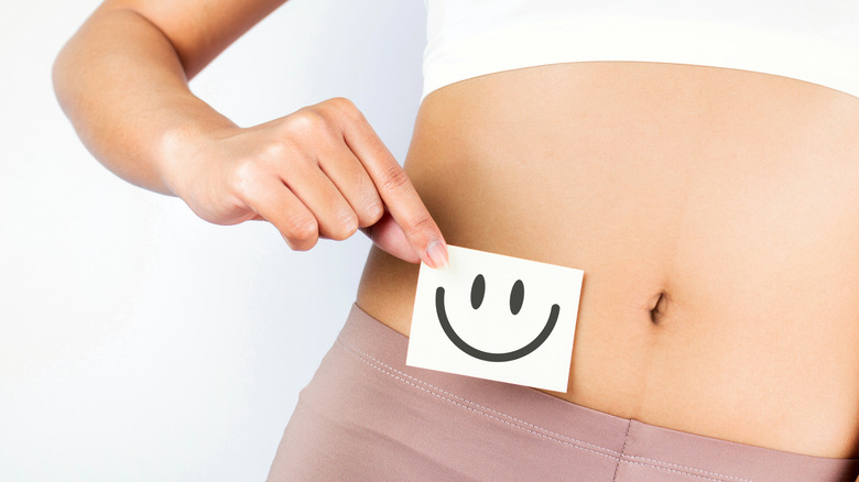 Paper smile on woman's stomach