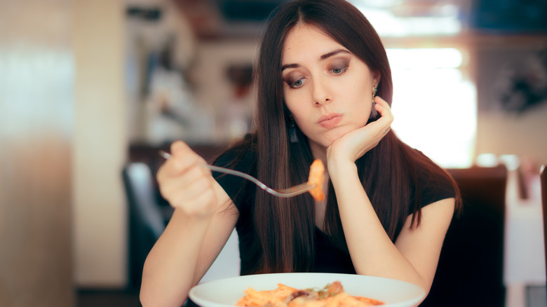 Woman at restaurant looking at plate