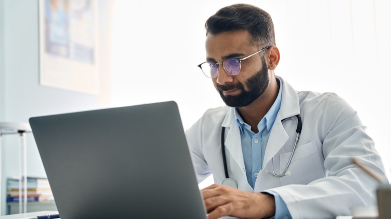 Indian doctor looking at computer