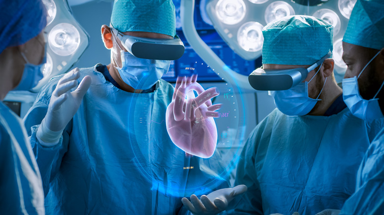doctors performing heart surgery with hologram of heart
