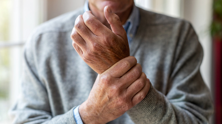 A man holds his wrist