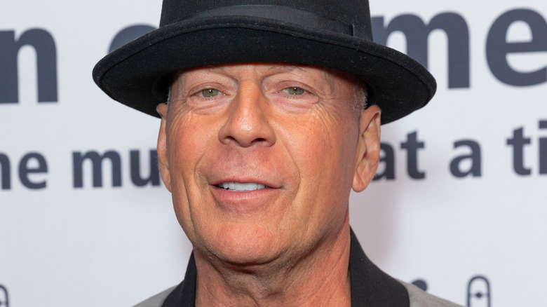 Bruce Willis wearing fedora smiling