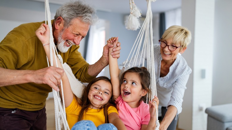 Grandfather and grandmother playing with grandchildren