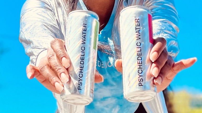 Woman holding Psychedelic Water cans