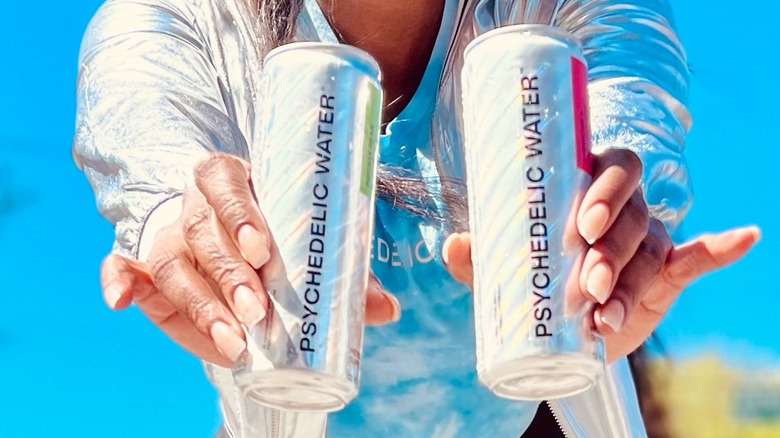 Person holding Psychedelic Water cans