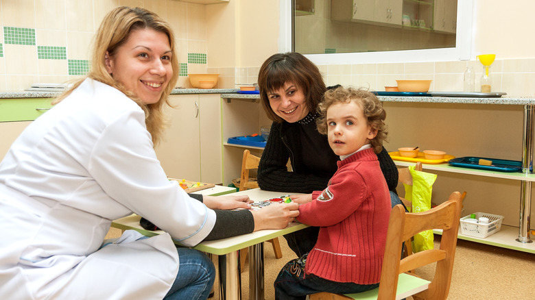 smiling doctor with child and mom