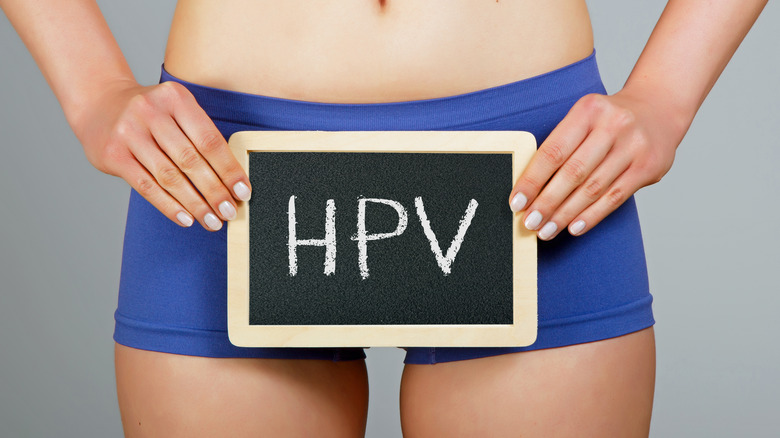 woman holding sign that reads "HPV"