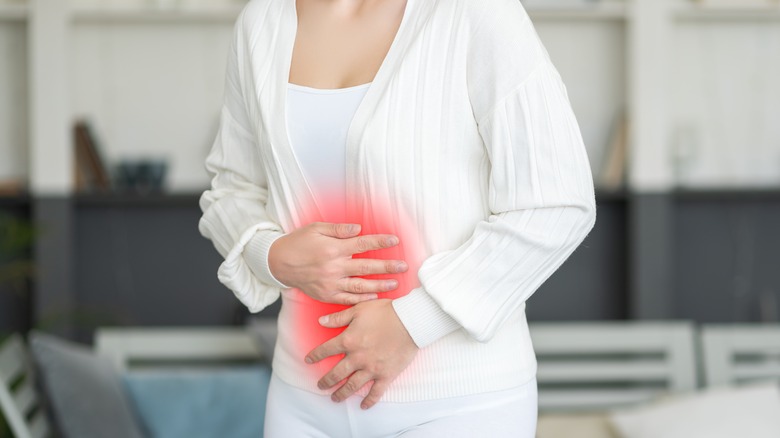 woman clutching stomach in pain 