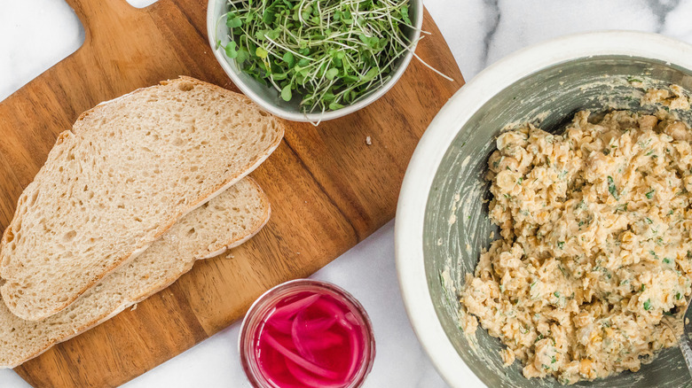 assembling chickpea salad sandwich