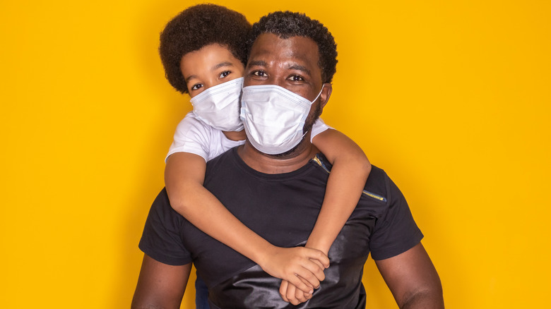 man and child hugging with yellow background