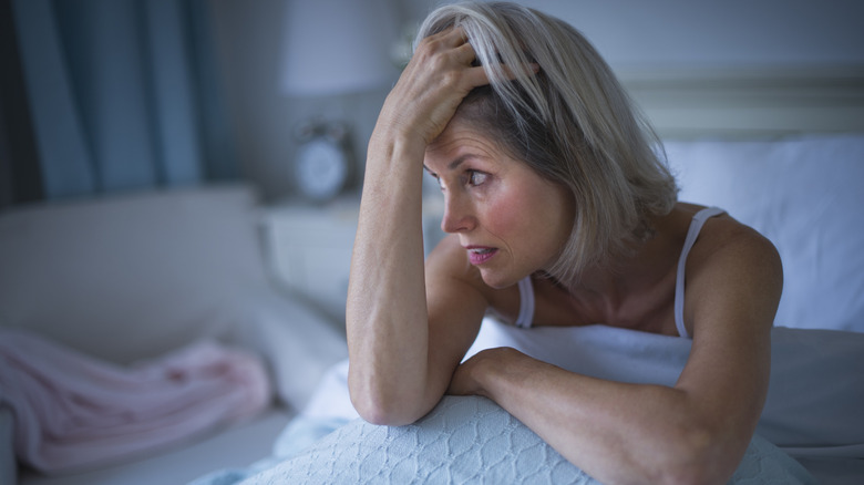 A frustrated woman sitting awake in bed