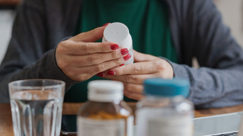 A woman's hands holding a bottle of medication