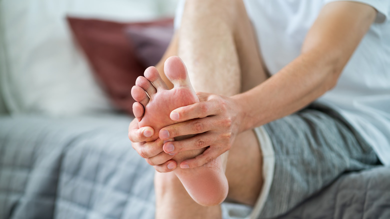 Person holding foot tenderly