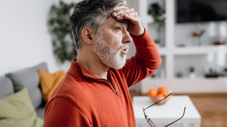 man feeling dizzy holding head