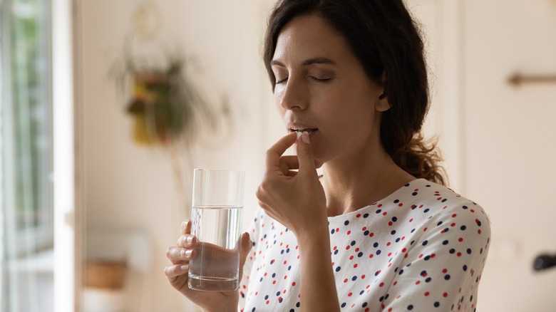 woman taking medication with water