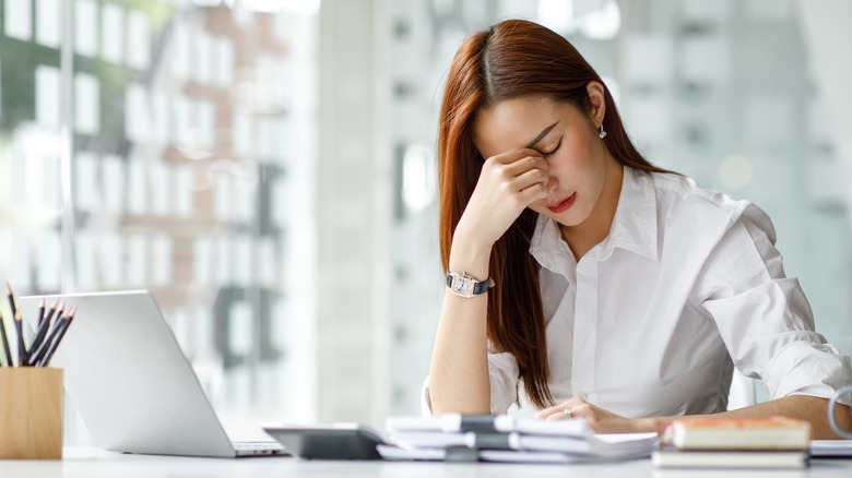 woman with headache at desk