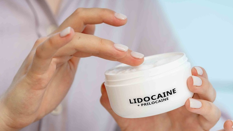 Woman grabbing lidocaine numbing cream