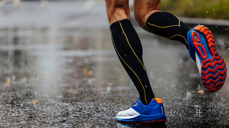 A runner wearing black and yellow compression socks