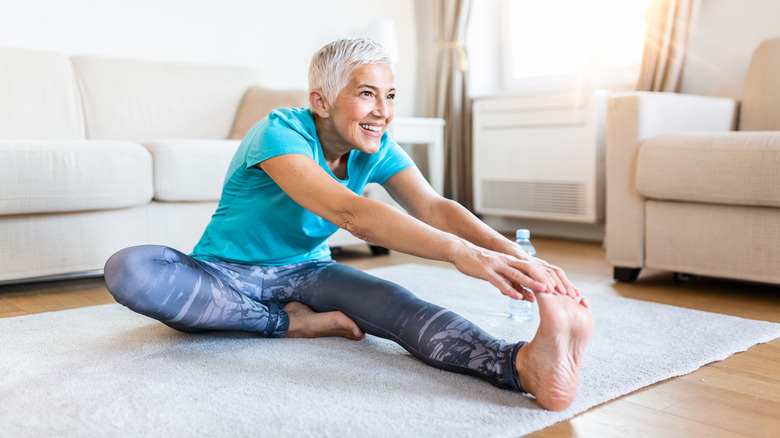 Woman sitting on the floor stretching