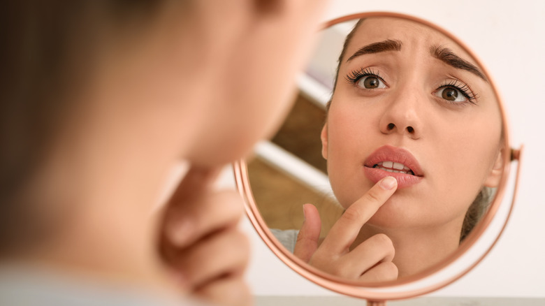Woman looking at lip in mirror