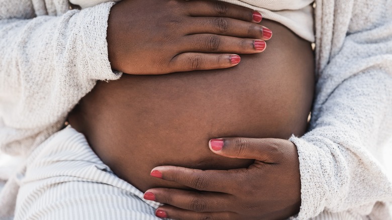 Pregnant woman holding her belly