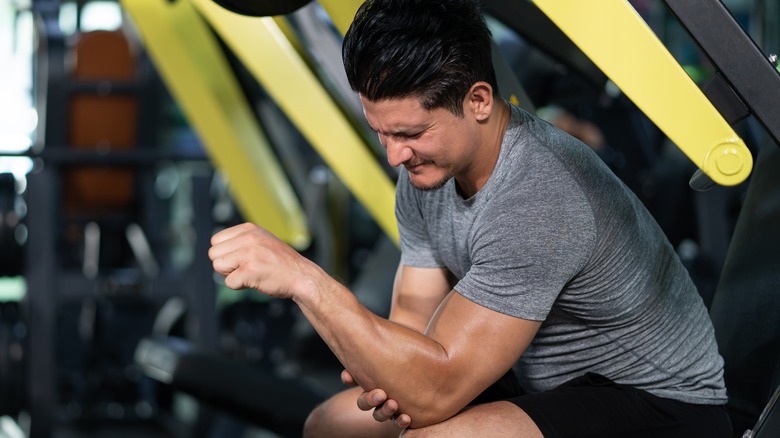 Man holding his arm at the gym