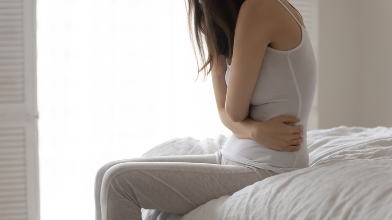 woman sitting and holding stomach