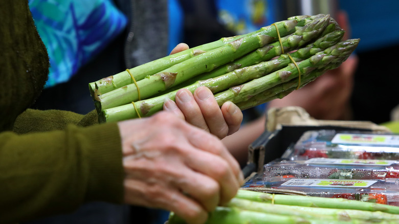 a person selecting asparagus