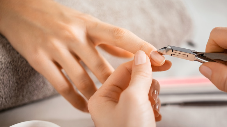 person getting their cuticles trimmed