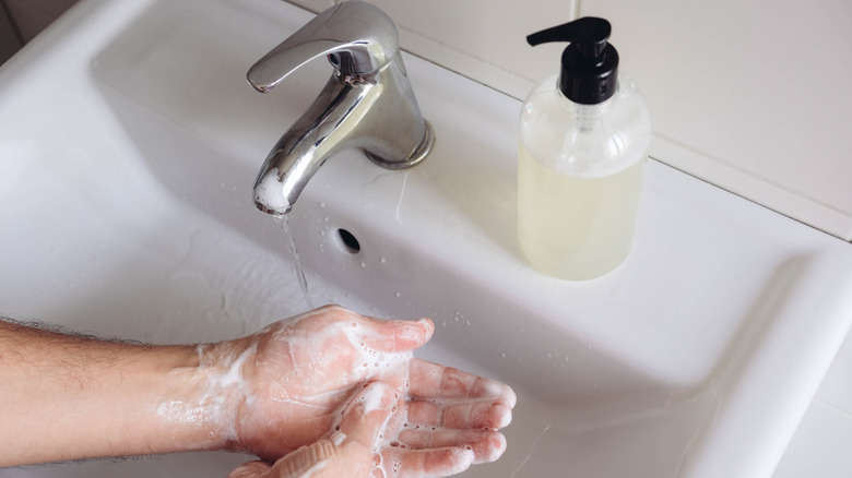 person washing their hands with soap