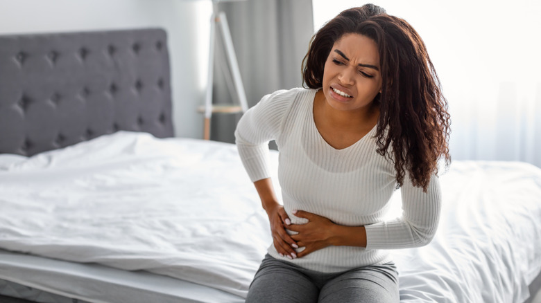 woman holding abdomen in pain