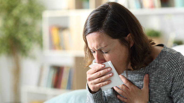 woman coughing and touching chest