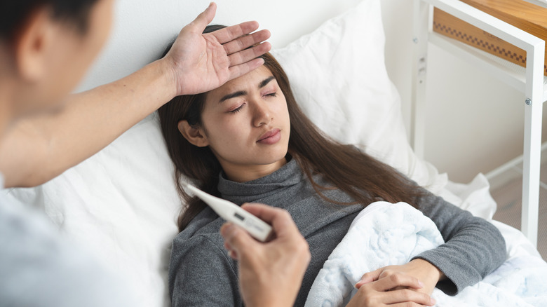 husband checking for fever in sick woman