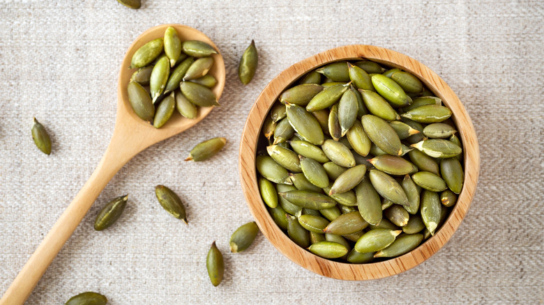 pumpkin seeds in a wooden bowl and spoon