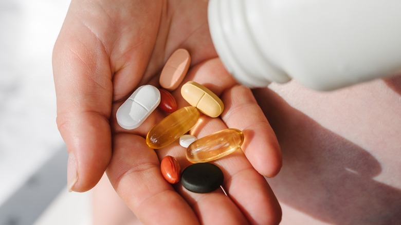 Person pouring supplements into her hand