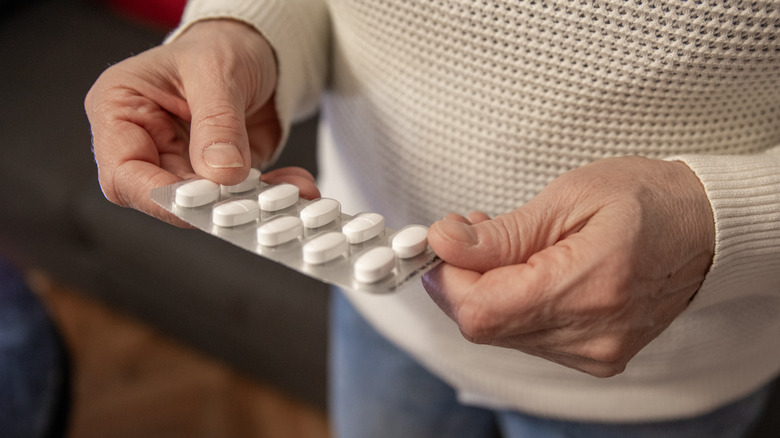 Person holding blister pack of opioid pills