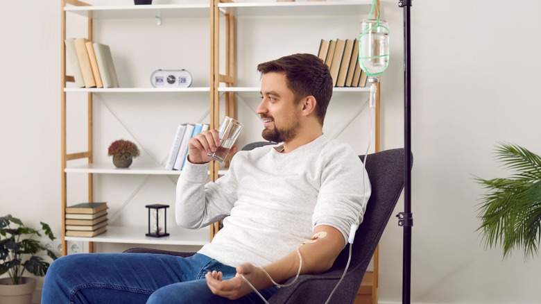 Man receiving chemotherapy while drinking water