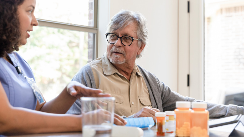 Health professional explaining medications to man