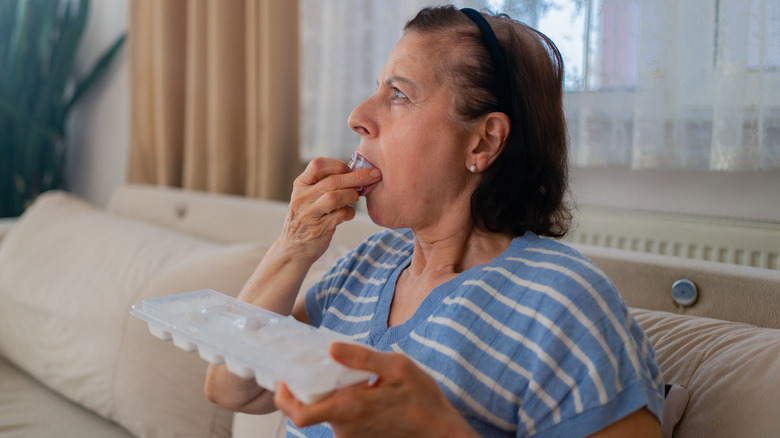 Woman putting ice in her mouth