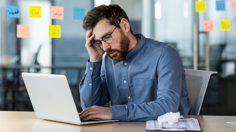 A man at worked stressed out at his computer