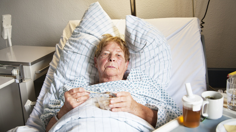 Woman in hospital bed with food that she's not eating