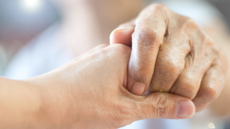 close up of young person holding older person's hand