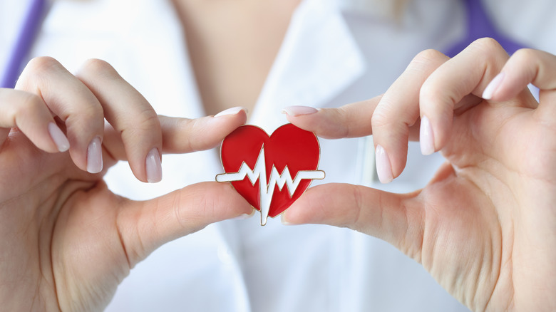 woman holding heart model