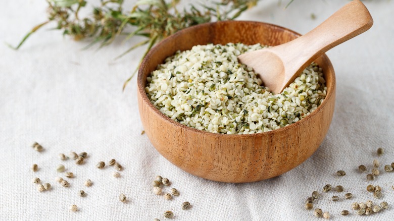 Wooden bowl with hemp seeds and a spoon