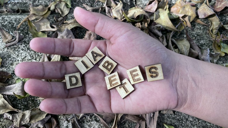 wood letters in palm spell diabetes with leaves in background