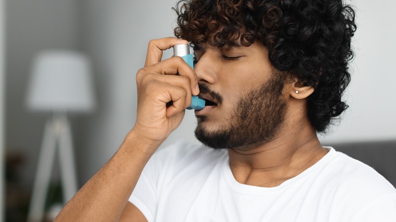 Young man using nebulizer for asthma