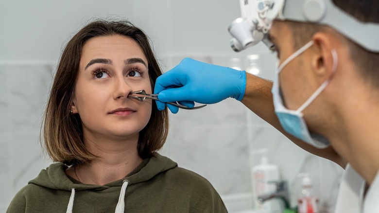 ENT specialist examining patient's nose