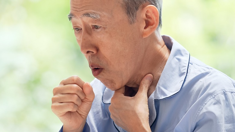 coughing elderly asian man