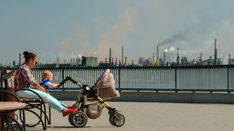 woman with baby sitting near pollution