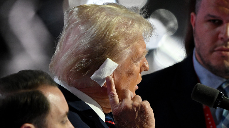 Donald Trump pointing to injured ear